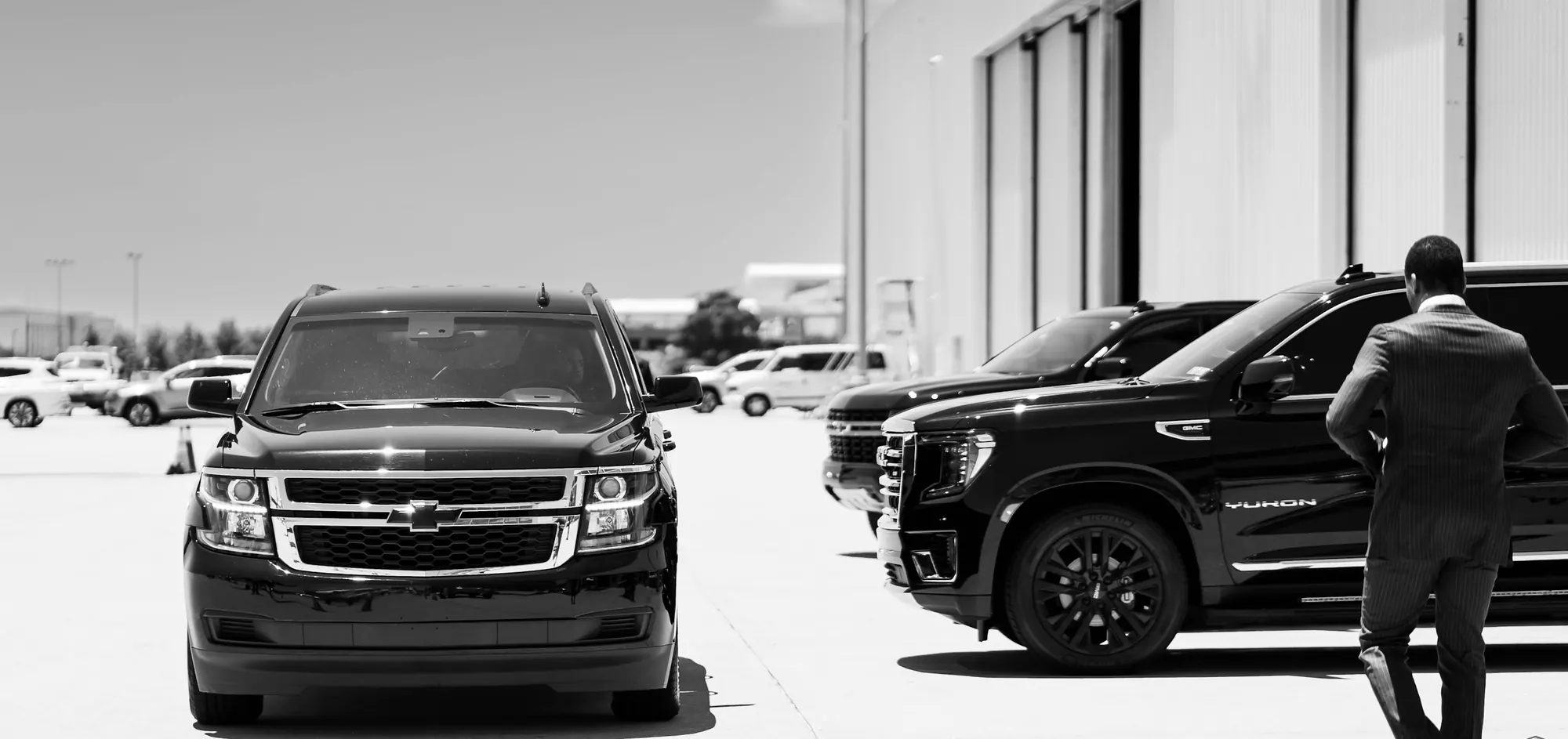 Black SUVs with a security officer